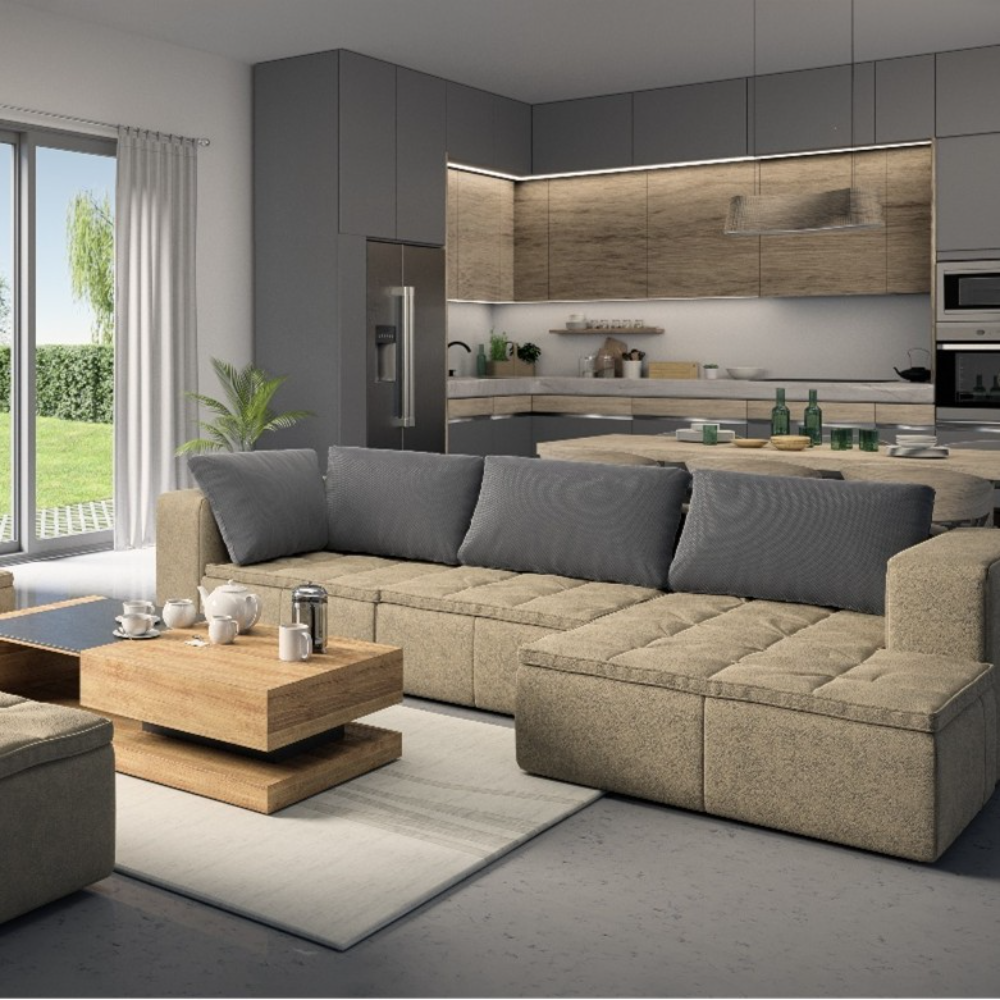 Modern open-plan living room and kitchen, ideal for ADU Construction, featuring a beige sectional sofa, wooden coffee table, gray cabinets, and a large window overlooking a green outdoor area.